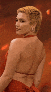 a woman with short blonde hair is wearing earrings and a red dress