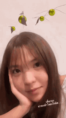 a girl with a hand on her face has a sticker on her head that says ' a '