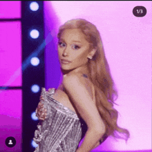ariana grande is wearing a wig and a silver dress .