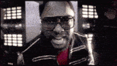 a man wearing glasses and a jacket is smiling at the camera