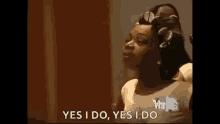 a woman with curlers in her hair is getting her hair done .