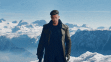 a man standing on top of a snowy mountain holding a gun