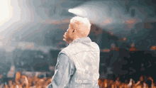 a man wearing a denim jacket that says versace