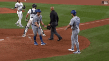 a baseball player in a dodgers uniform is walking towards the base