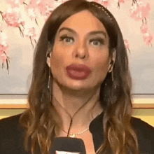 a woman with big lips is talking into a microphone while wearing headphones .