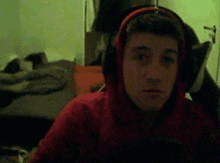 a young man wearing headphones and a red hoodie .