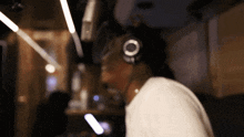 a man wearing headphones and a white shirt looks down