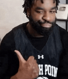 a man with a beard is wearing an under armour jersey that says h point