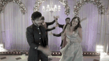 a man and a woman are dancing in front of a purple curtain