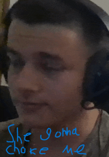 a man wearing headphones with the words " she gonna choke me " written in blue