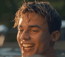a young man is smiling while swimming in a pool of water