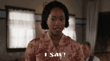 a woman in a pink floral shirt says i say