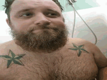 a man with a beard and tattoos on his chest is taking a shower in a bathroom .