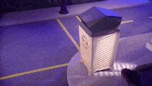 a trash can is sitting on a table in a parking lot with a purple background .