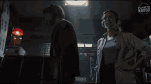 a man and a woman are standing in a dark room with the word planeta on the top left