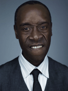 a man in a suit and tie is smiling and making a funny face