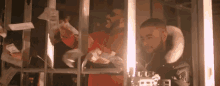 two men are standing in a prison cell holding money and a guitar .