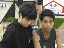 two young men are standing in front of a pinoy brother so sign