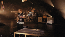 a man playing a guitar on a stage with the letter d in the corner
