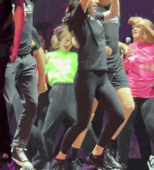 a group of people are dancing on a stage with one wearing a shirt that says ' i love you ' on it