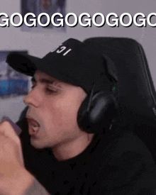 a man wearing headphones and a hat says gogogogogogog