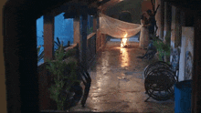 a man and a woman are standing next to a fire on a porch at night .