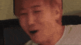 a man is making a funny face with his eyes closed .