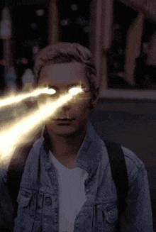 a man in a denim jacket has a lightning bolt in his eyes