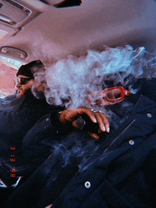 a man smoking a cigarette in a car with a date stamp of 3 13 98