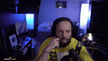 a man wearing headphones stands in front of a microphone with the words brocash 1 month in the corner