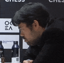 a man sitting in front of a chess board