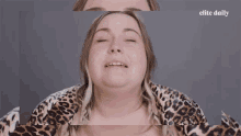 a woman in a leopard print shirt is making a funny face in front of a banner that says ughh