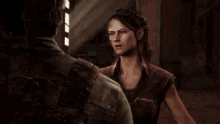 a man and a woman are standing next to each other in a dark room and talking to each other .