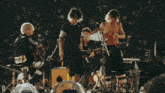 a crowd of people watching a band on stage with the letter d on the bottom left