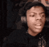 a close up of a person wearing headphones and making a funny face .