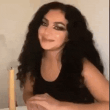 a woman is sitting at a table with a candle in front of her .