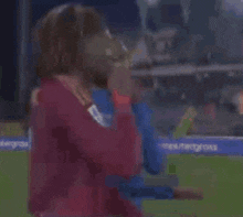 a soccer player with dreadlocks is shaking hands with another player on the field .