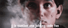 a close up of a man smoking a cigarette with the words jj is number one johnny cade fan below him