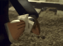 a close up of a person 's foot with a glove on