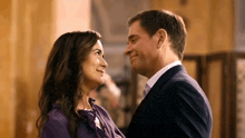 a man and woman are looking at each other and smiling .