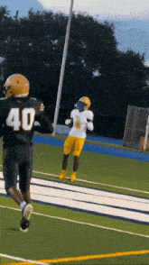 a football player with the number 40 on his jersey is running on the field