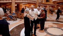 a man in a tuxedo is dancing with two women