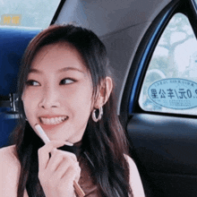 a woman sitting in a car with a sticker on the back window that says ' 00 ' on it