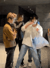 a group of young men are standing next to each other and one of them is wearing a white shirt