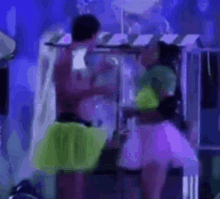 a man and a woman are standing next to each other on a stage in a dark room .