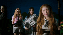 a girl holding a boombox that says ' aiwa ' on the front