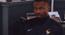 a man wearing a blue nike shirt with a rooster on the front