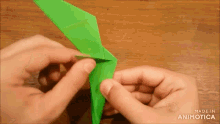 a person is making an origami bird with the words made in animotica on the bottom right