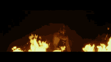 a person is standing in front of a fire