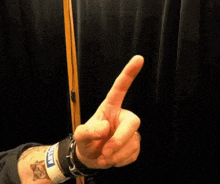 a person with a tattoo on their arm is making a middle finger sign